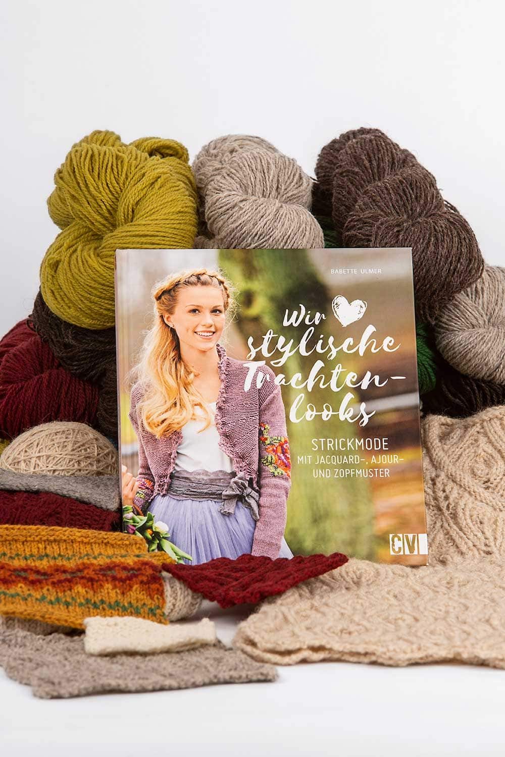 Wir lieben stylische Trachtenlooks bunte Wollen aufgestapelt als Stimmungsbild mit dem Buch ,,Wir lieben stylische Trachtenlooks" von Babette Ulmer