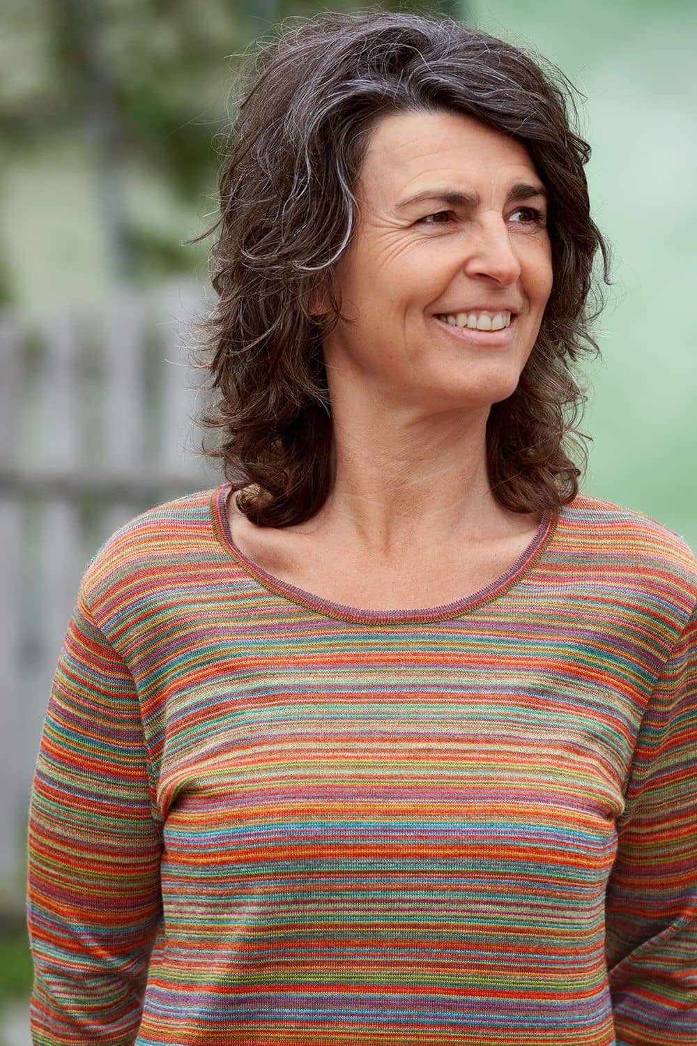 Portraitaufnahme von Frau mit pinkem/buntem Streifenshirt aus bio Wolle (kbT) vom Finkhof