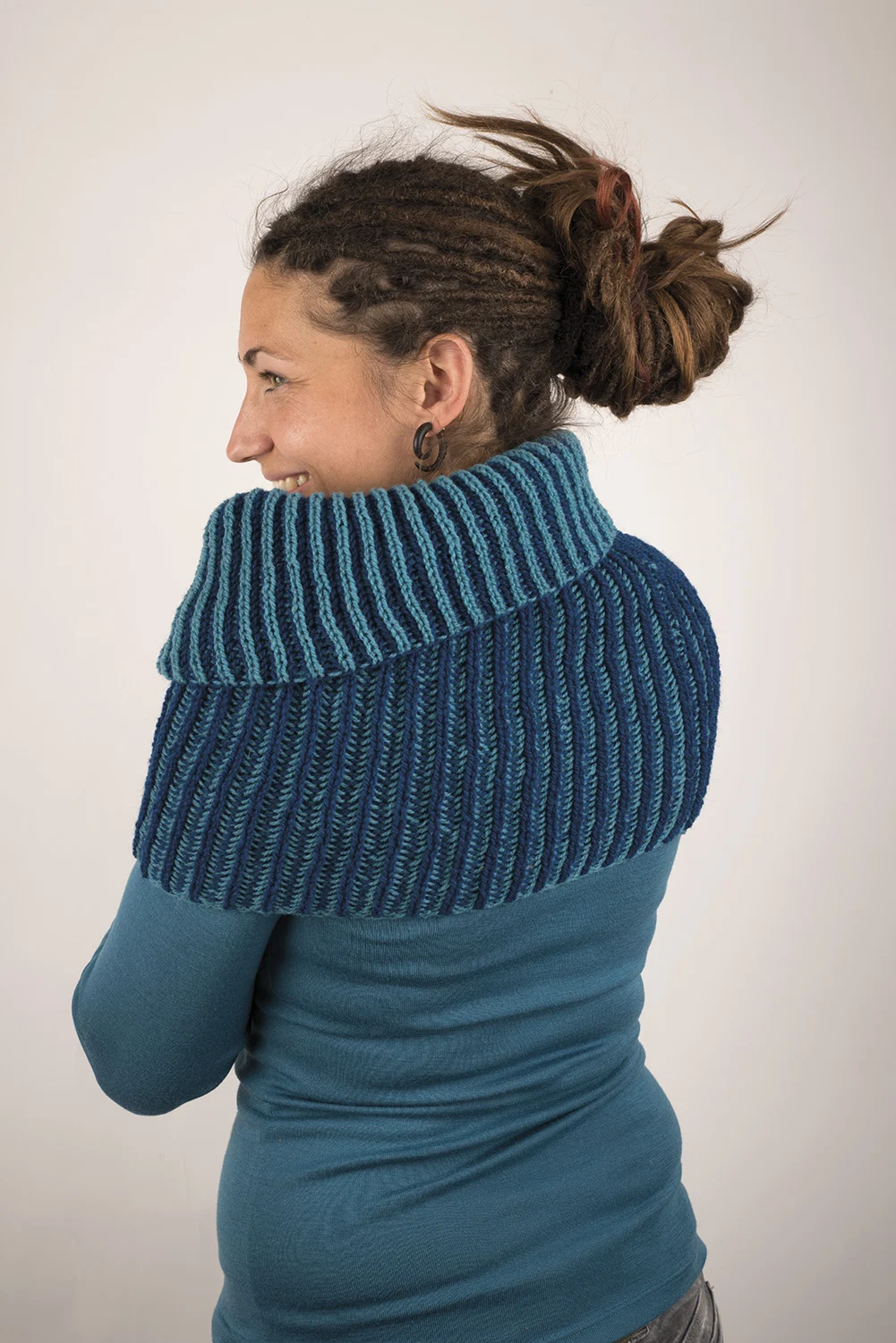 Frau trägt blaues Shirt und blauen Loopschal