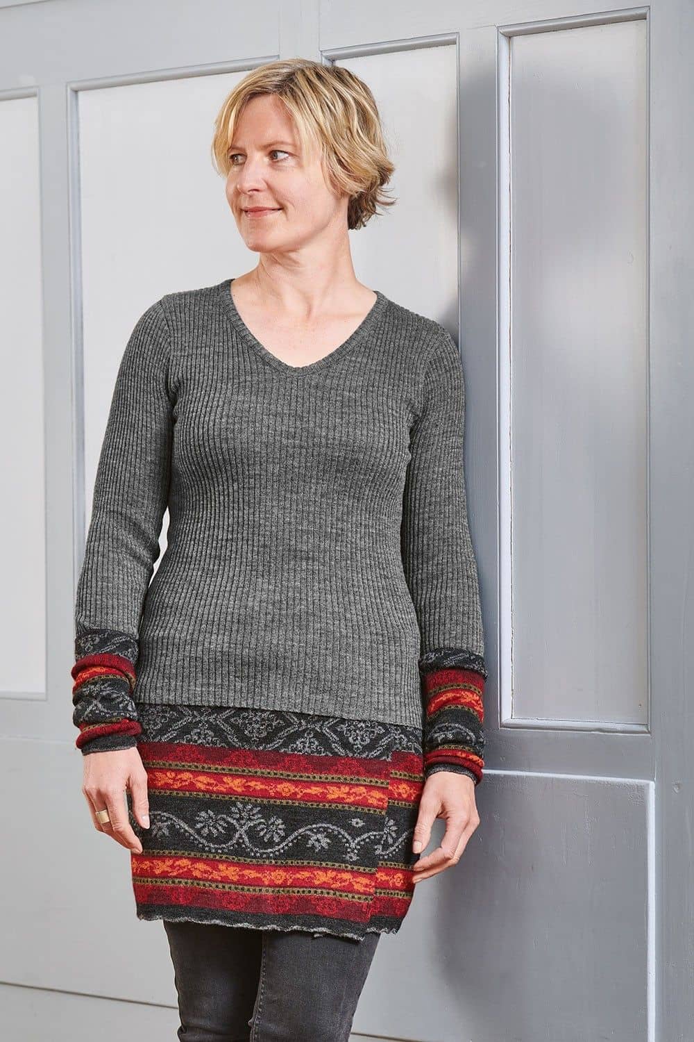 Frau trägt gemusterten Cacheur, Stulpen und graues Shirt mit Rippstoff und V Ausschnitt aus bio Finkhof Wolle (kbT)