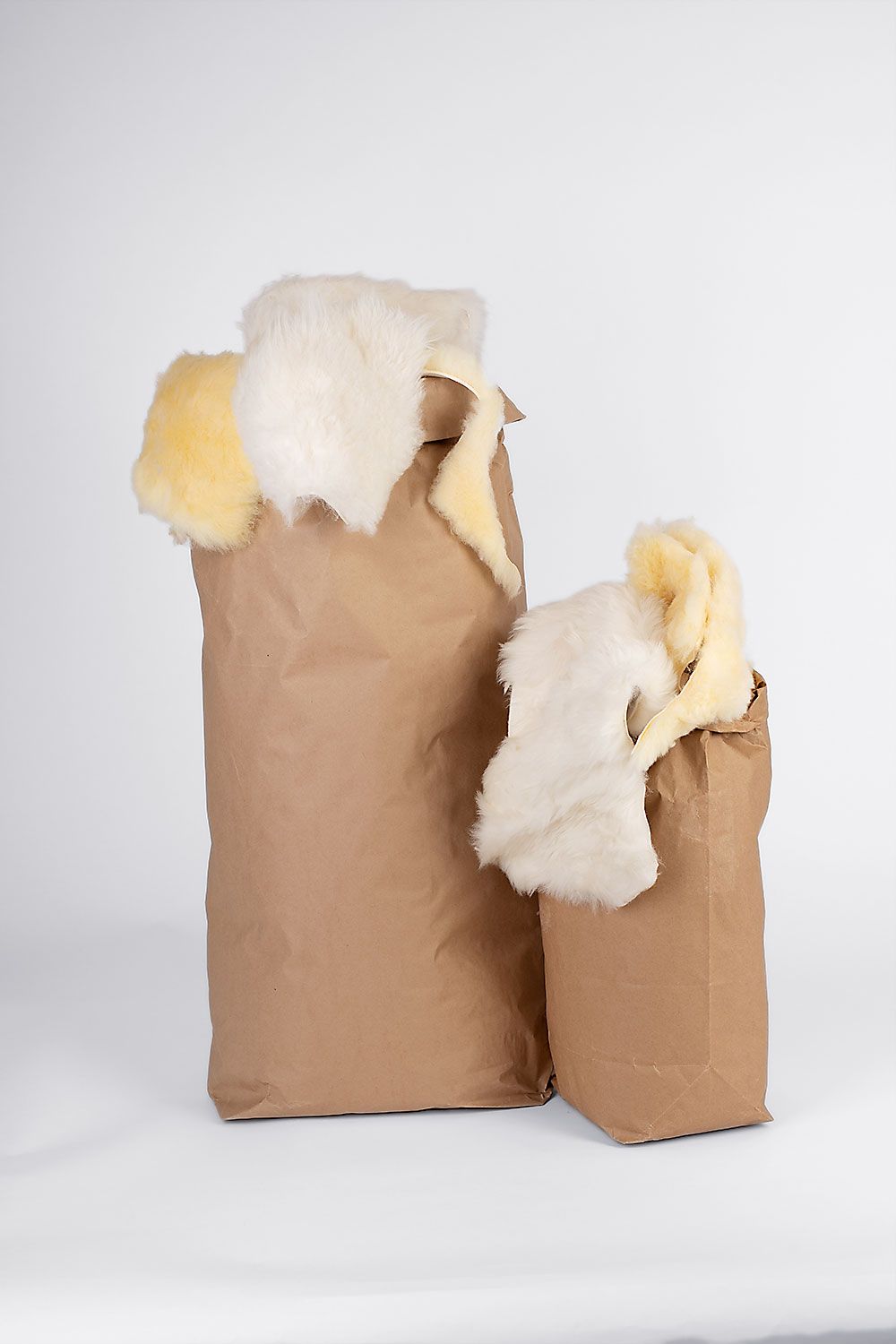 Fellreste kleine und große Fellreste vom Finkhof in braunen Papiertüten nebeneinander gestellt