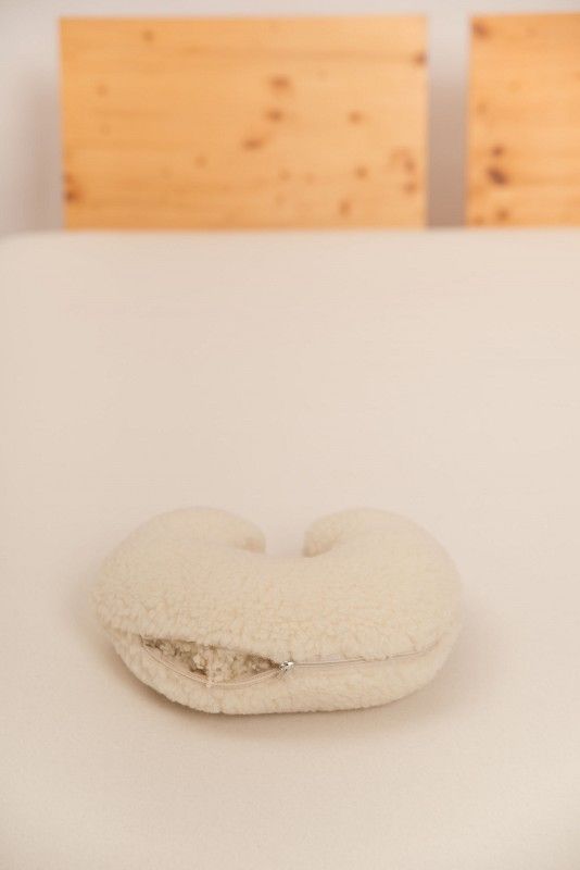 naturweißes Nackenhörnchen vom Finkhof mit Wollplüschbezug aus bio Wolle (kbT) auf hellem Laken geöffnet