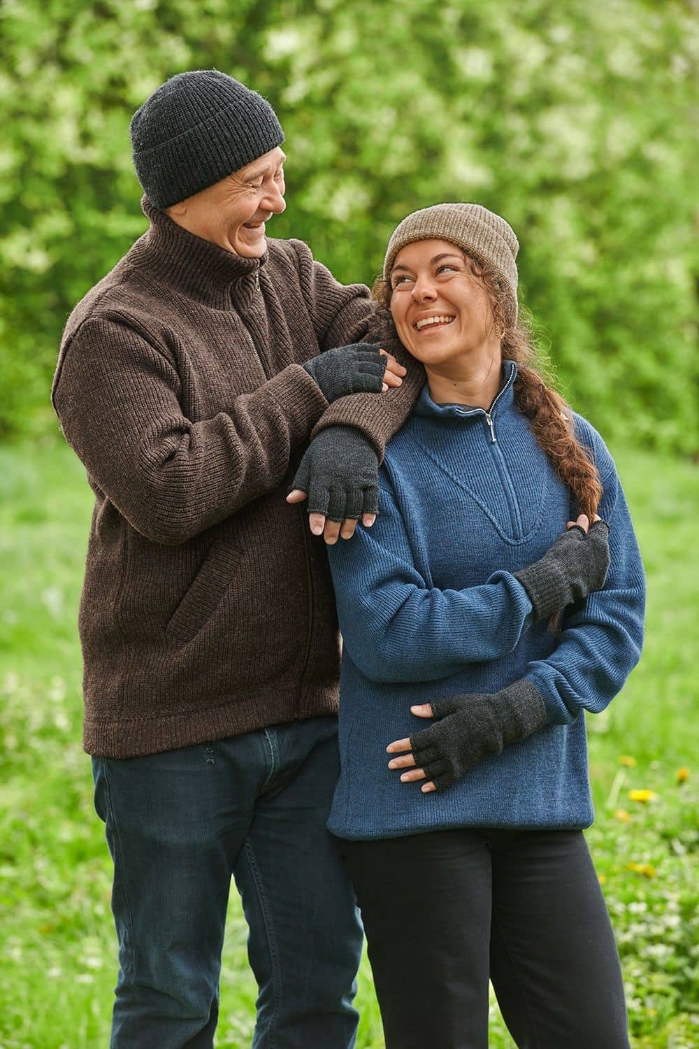 Strickhandschuhe ohne Finger aus reiner Bio-Schurwolle Mann und Frau mit Troyer und Mütze tragen anthrazitgraue Strickhandschuhe ohne Finger aus bio Wolle (kbT) vom Finkhof