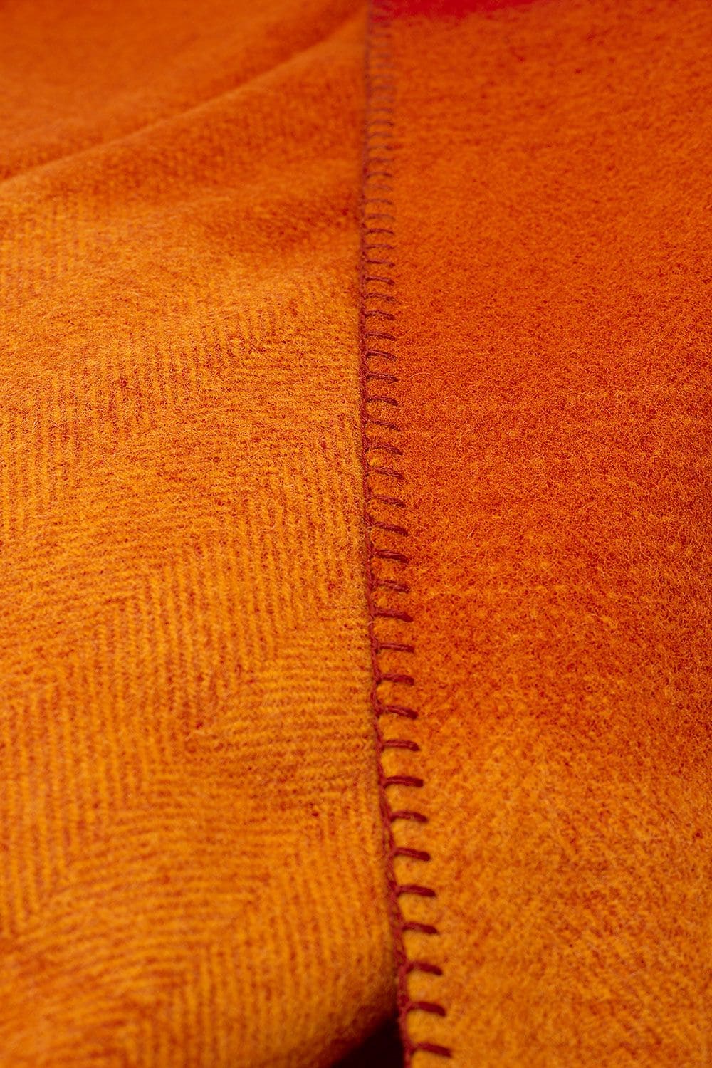 Nahaufnahme Wolldecke in rot und orange aus bio Wolle (kbT)