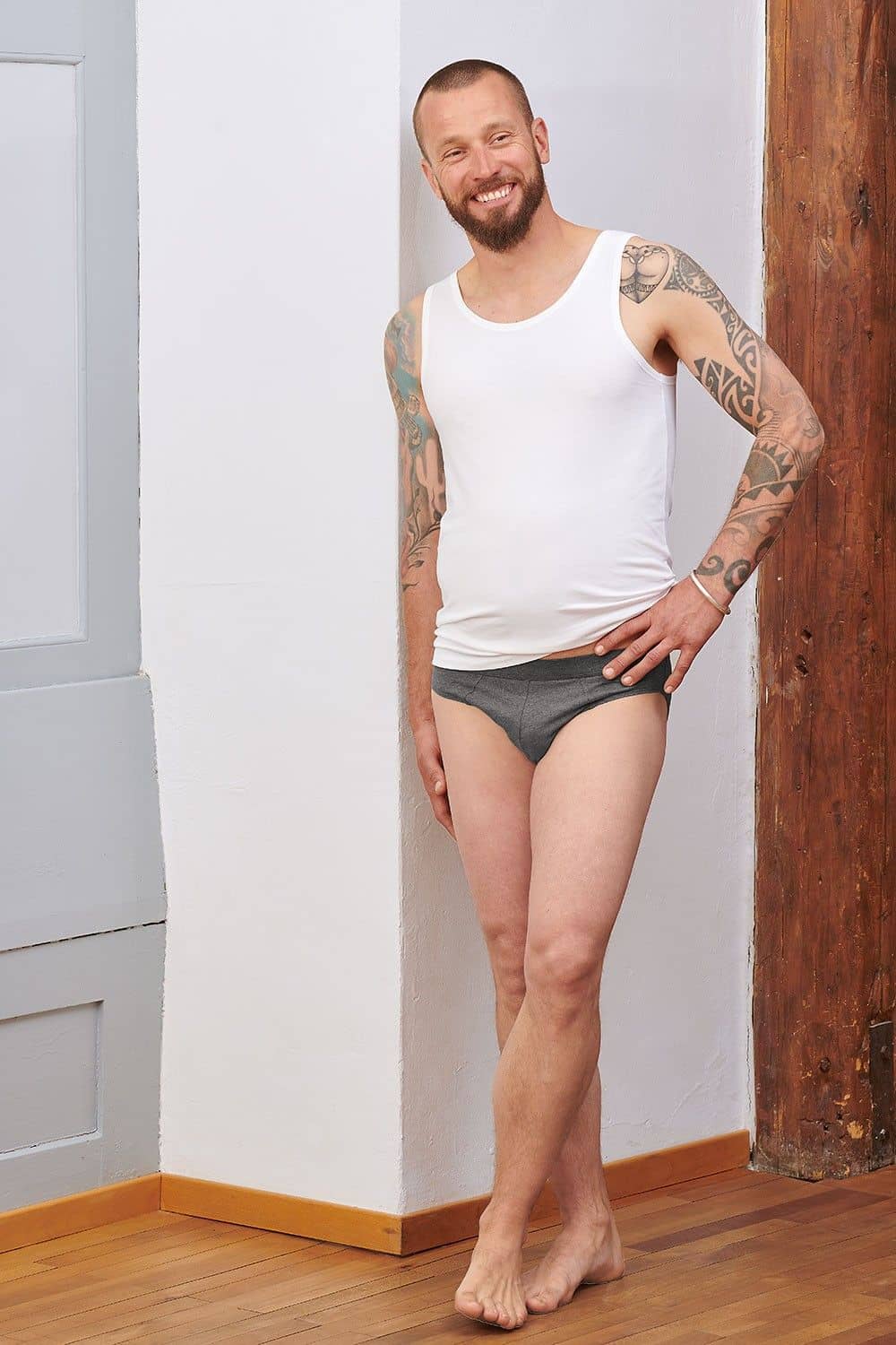 Mann mit weißem Top trägt dunkelgrauen Slip aus bio Baumwolle (kbA) und Elasthan