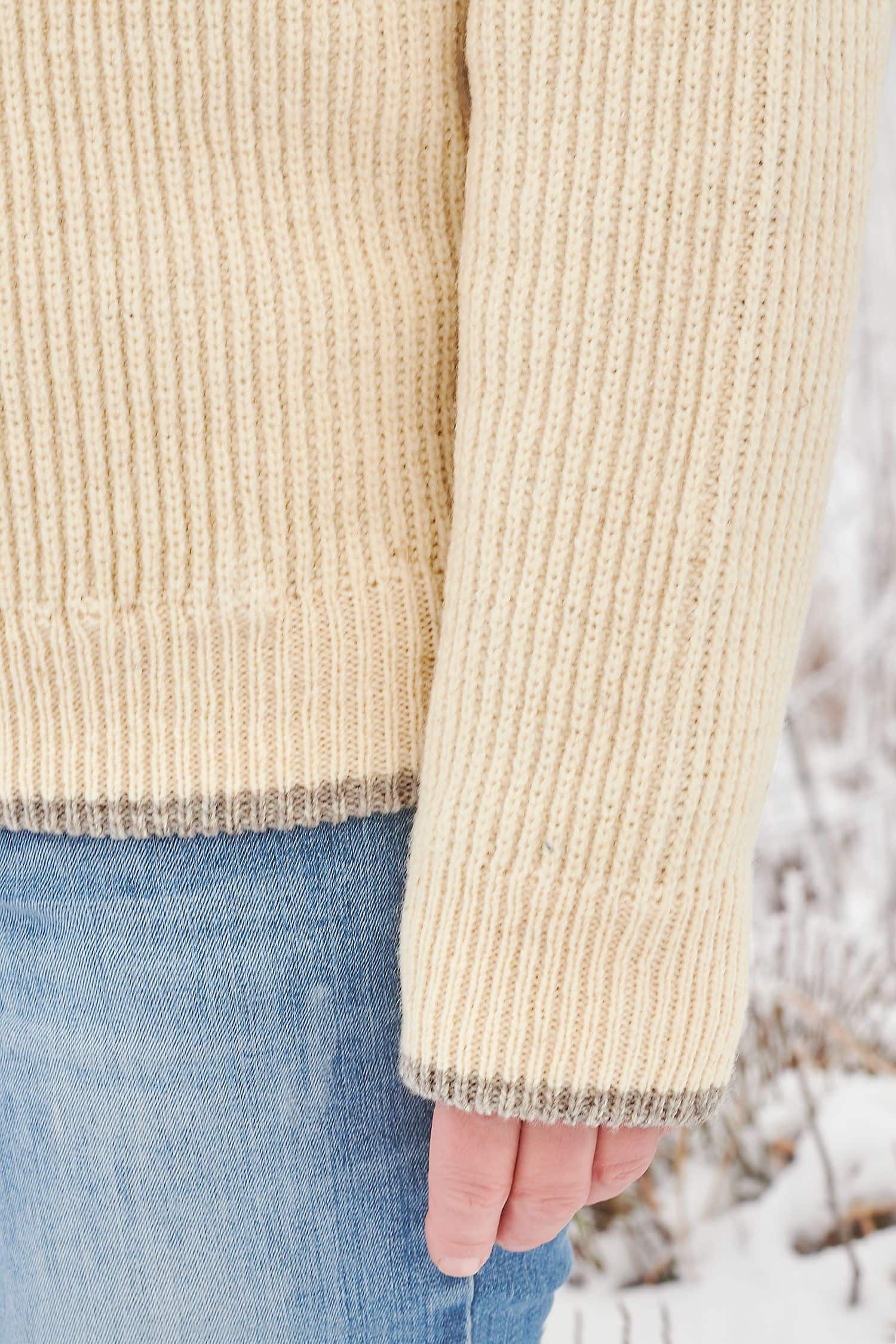 Detailansicht der grauen Abschlüsse des naturweißen Finkhof Troyer aus bio Wolle (kbT)