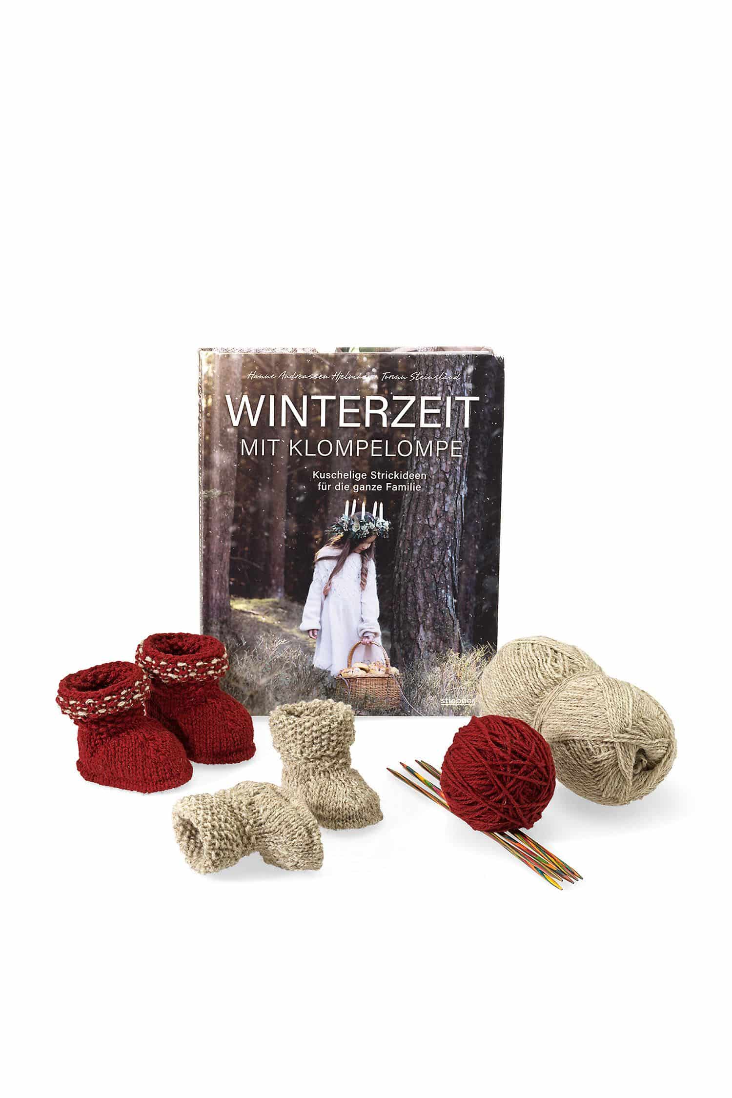 Winterzeit mit Klompelompe: Kuschelige Strickanleitungen für die ganze Familie. Von Mütze stricken bis ausgefallene Pullover stricken: Strickmuster für Groß und Klein. Buch ,,Winterzeit mit Klompelompe" mit roten, grauen Wollknäulen und Babybschuhen
