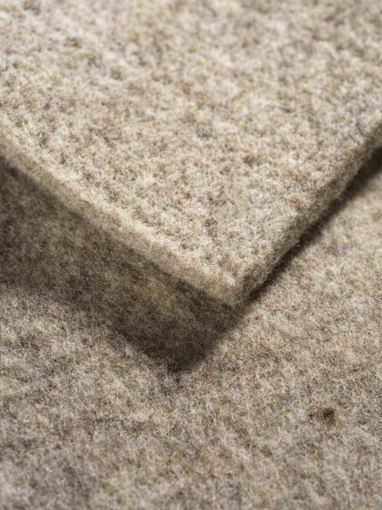 Nahaufnahme von grauer Finkhof Sitzauflage aus bio Wolle (kbT)