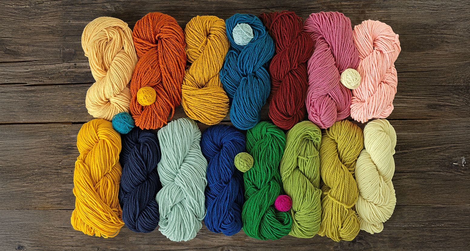 Finkhof Wolle in verschiedenen Farben ordentlich auf braunem Holzboden