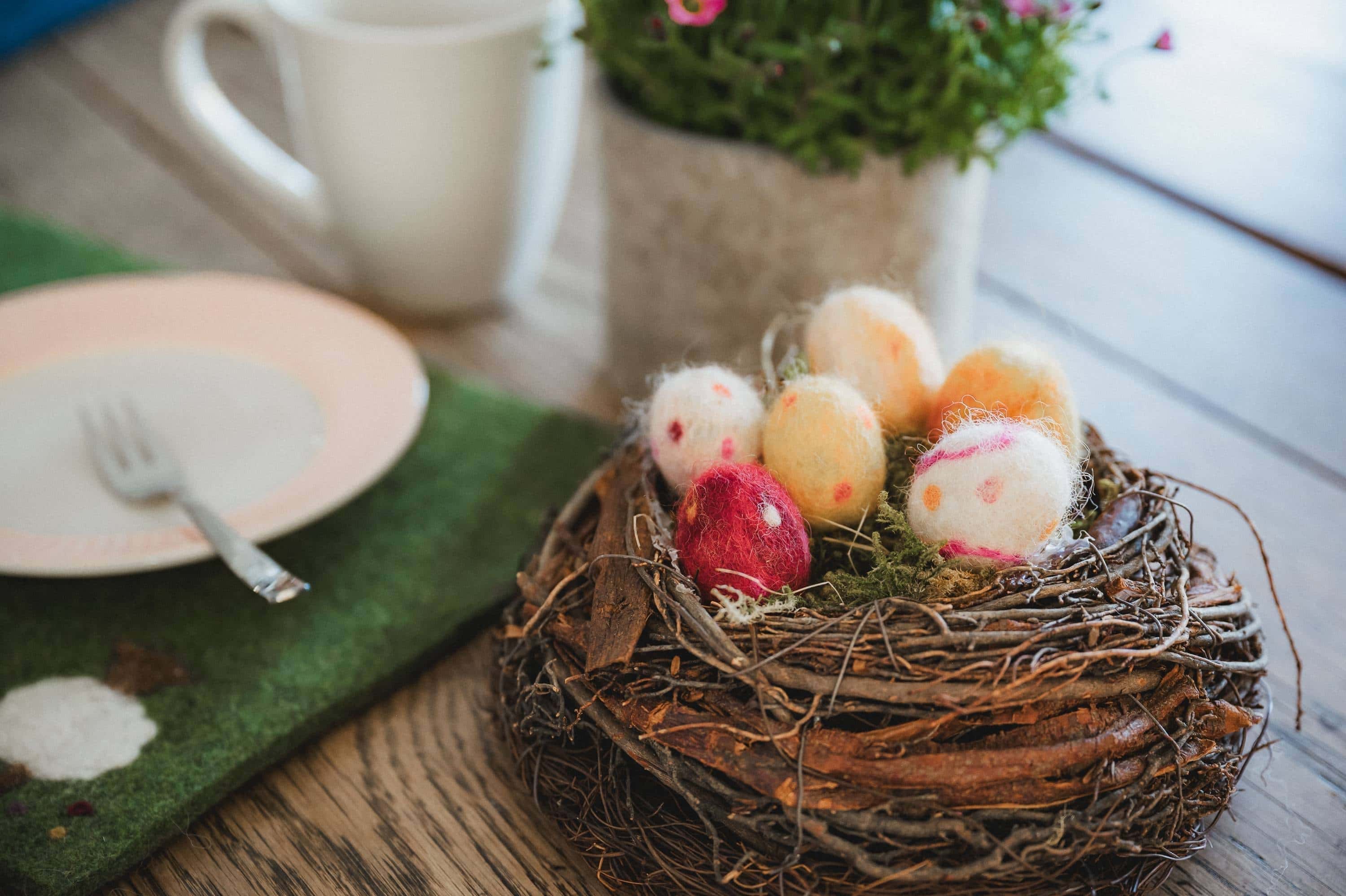 Bastelanleitung - bunte Filzostereier Osternest mit bunten Filzostereiern auf österlich dekoriertem Tisch