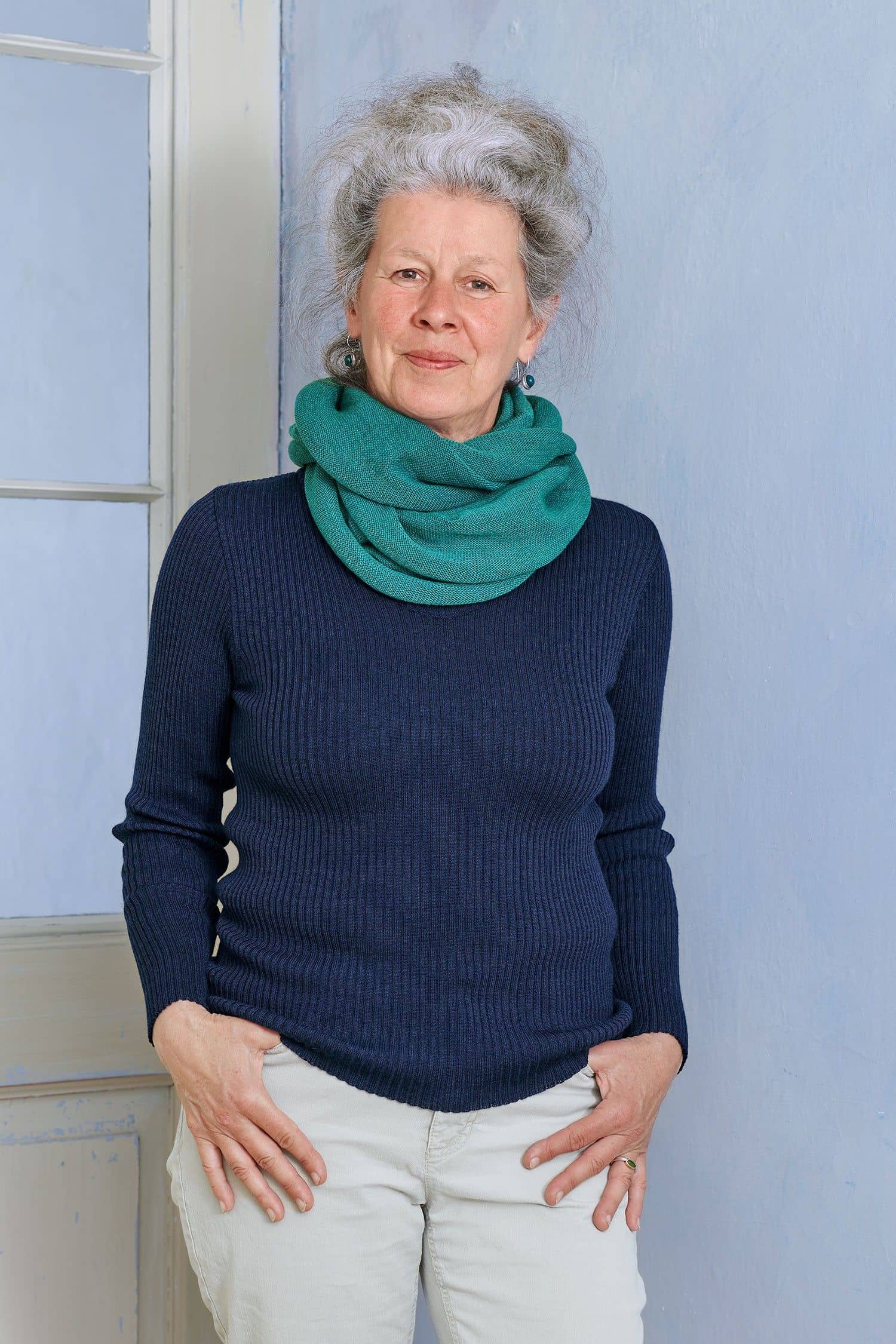 Frau mit marineblauem Rippshirt trägt türkisen Schlauchschal aus bio Wolle (kbT) vom Finkhof