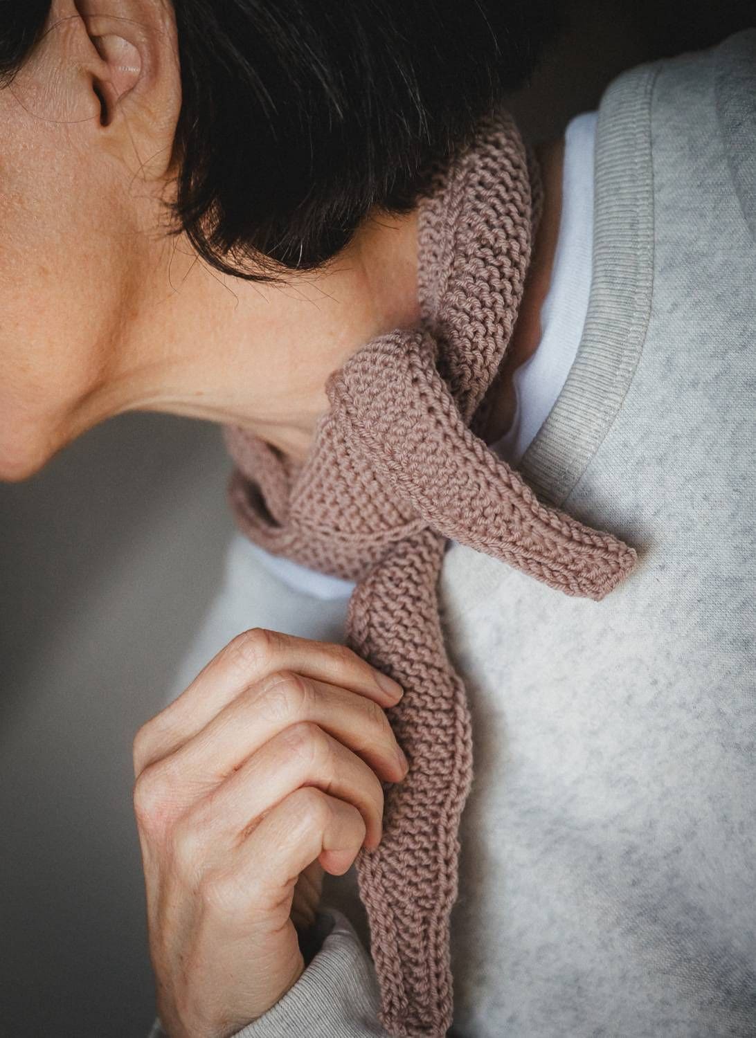 Frau mit kurzen Haaren trägt Mini-Schal aus Wolle vom Finkhof