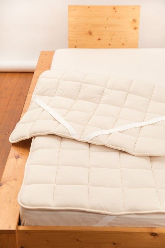 dickes Wollunterbett auf braunem Holzbett aus bio Wolle (kbT) und bio Baumwolle vom Finkhof mit 90x200cm