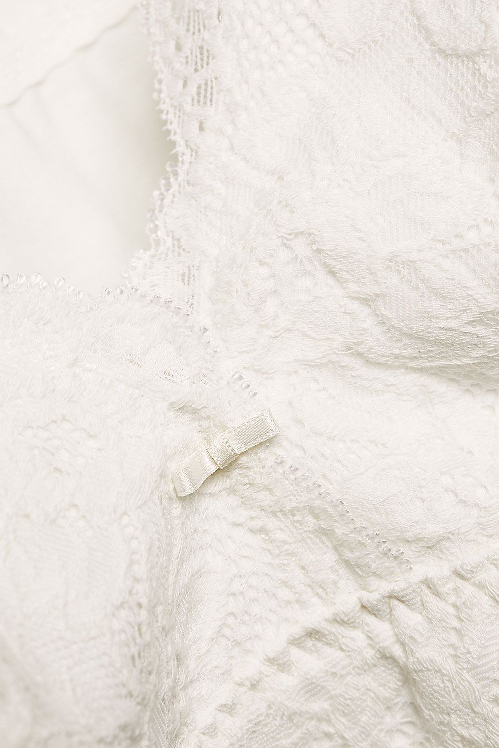 Detailftoto der Spitze des naturweißen Spitzentops mit integriertem BH aus bio Baumwolle (kbA) und Elasthan