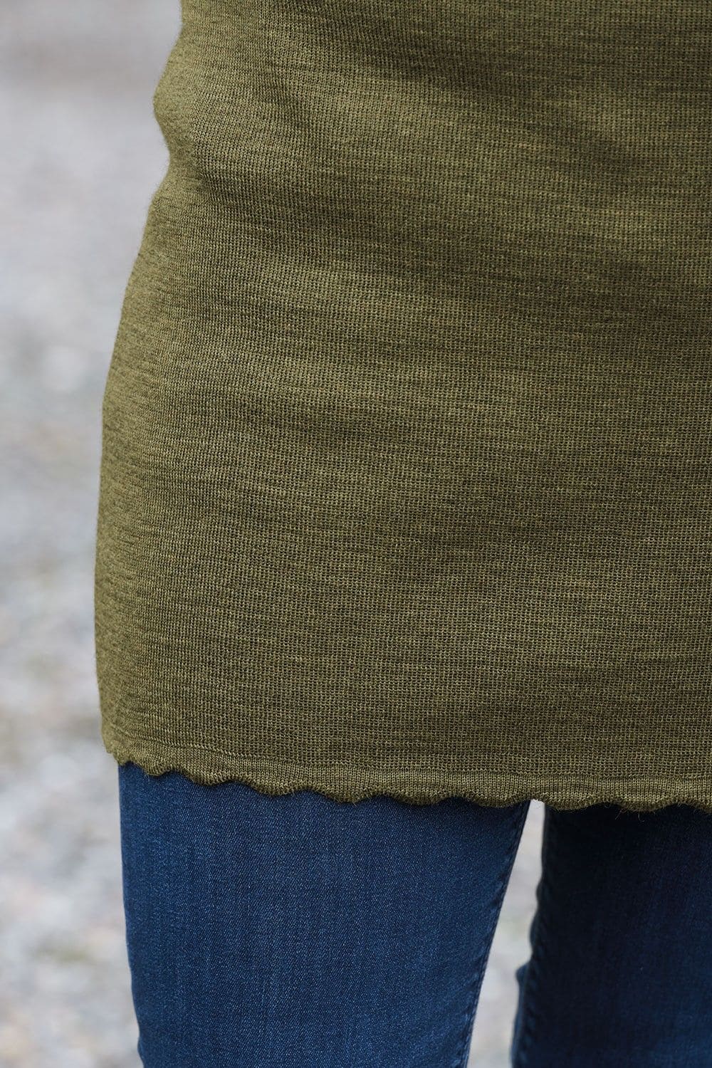 Nahaufnahme von grünem Finkhof Kurzrock aus bio Wolle (kbT) mit Jeans