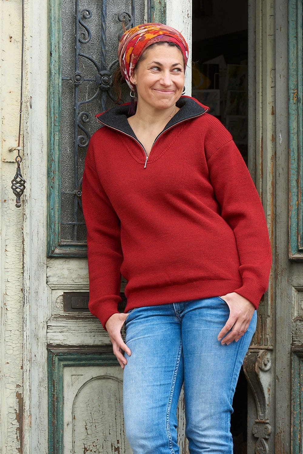 Frau trägt roten Troyer mit Reißverschluss aus bio Wolle (kbT) vom Finkhof, Jeans und Tuch auf dem Kopf
