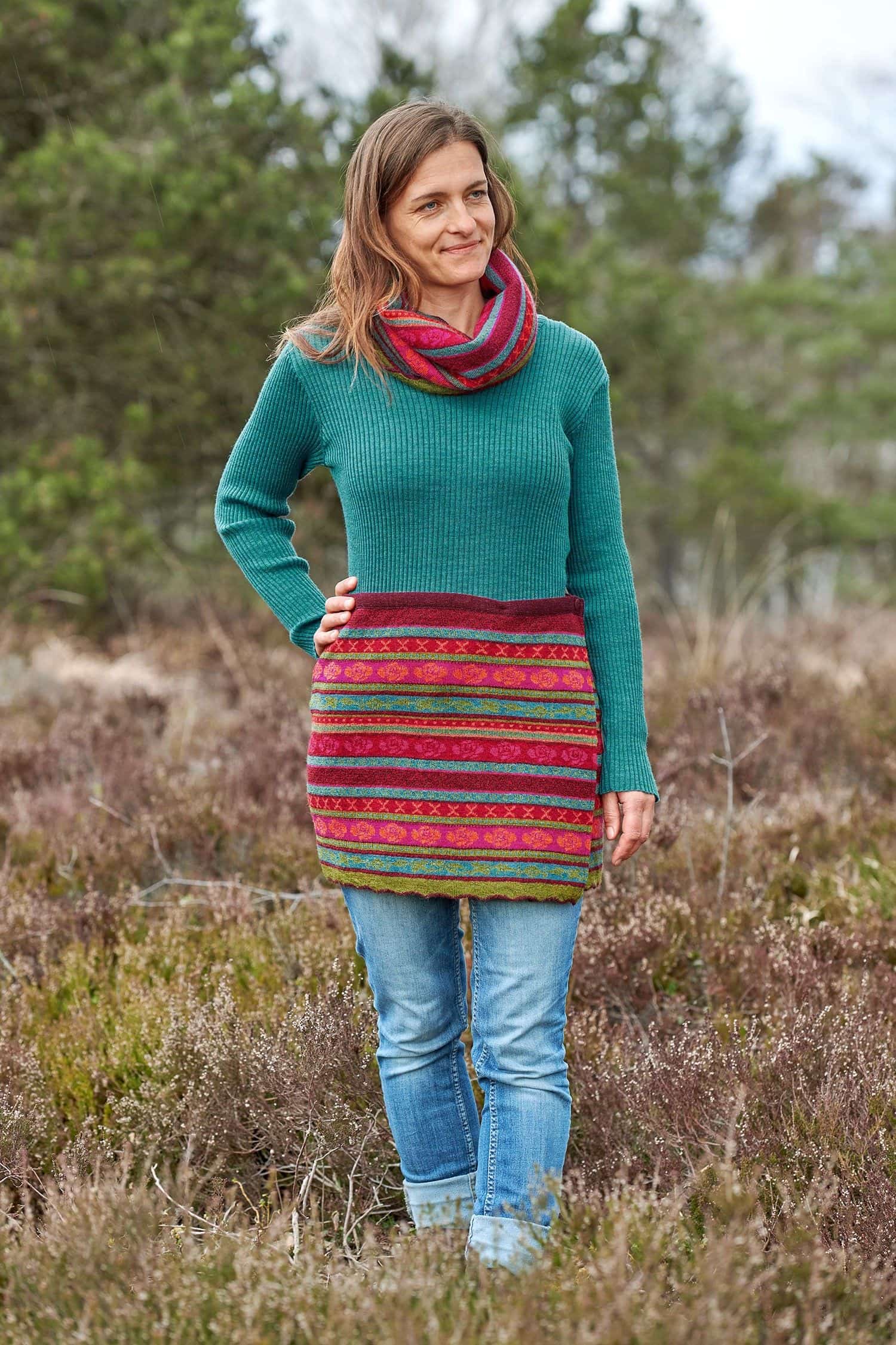 Frau mit türkisem Shirt trägt rot bunt gemusterten Cacheur und Loopschal aus bio Wolle (kbT)