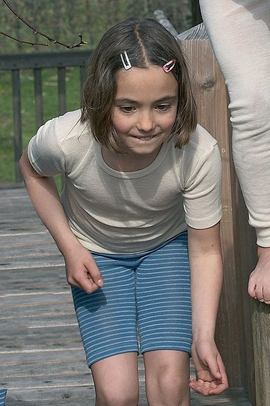 Geringelte Wollbermuda blau/naturweiß Mädchen trägt blau weiß geringelte Shorts aus bio Wolle (kbT) mit weißem kurzarm Wollshirt