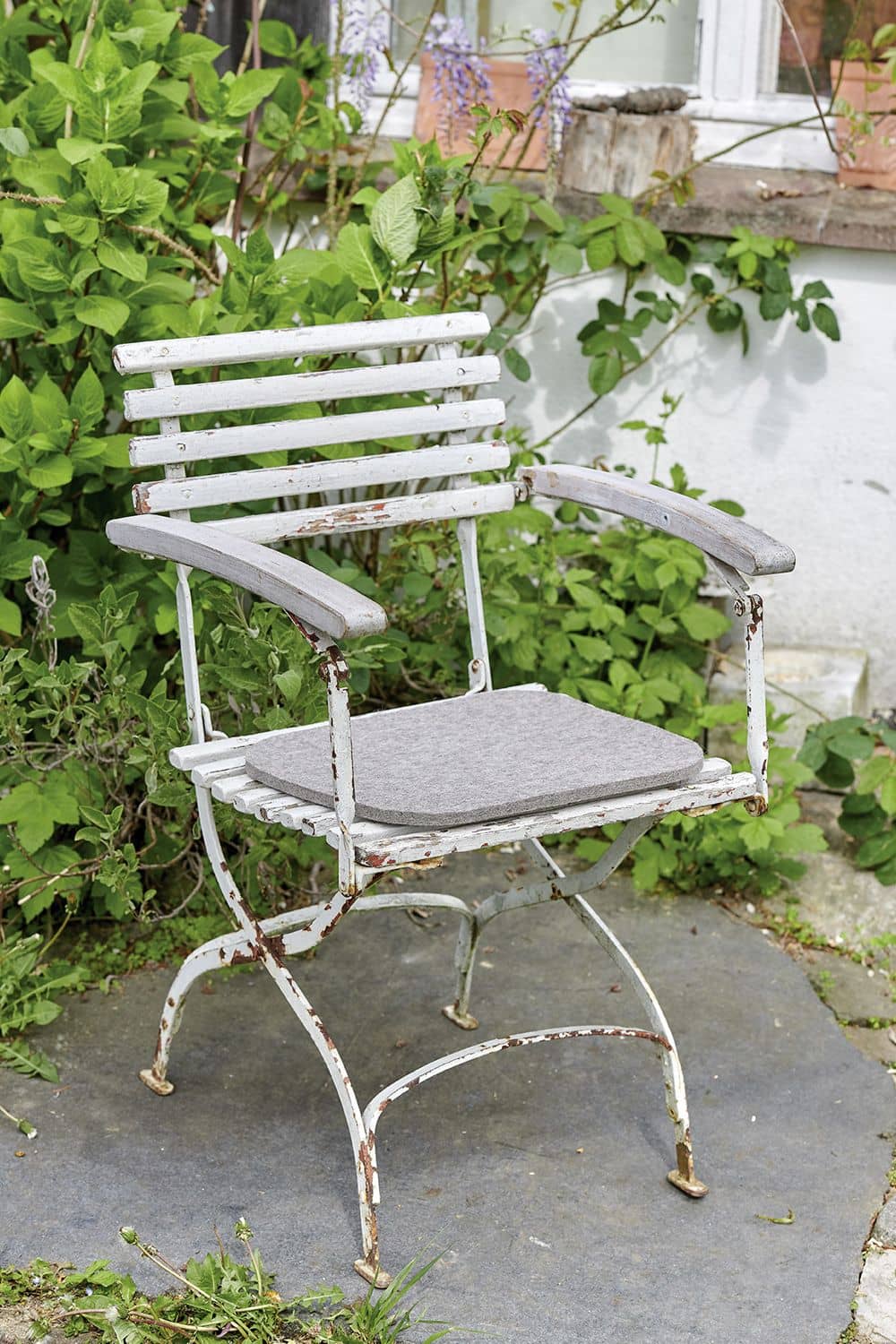 Filzauflage hellgrau 34 x 37 cm graue Filzauflage auf weißem Gartenstuhl in idyllischem Ambiente