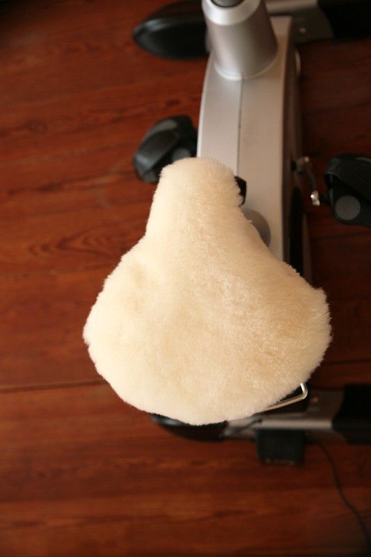 weißer extrabreiter pflanzlich gegerbter Sattelbezug vom Finkhof aus bio Wolle (kbT) und Schaffell auf Hometrainer von oben