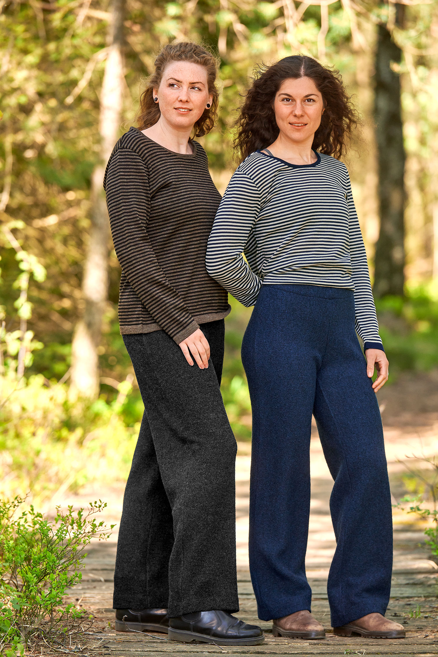 Frauen tragen Wollkrepphose aus bio Wolle (kbT) in anthrazit und marine mit Streifenshirts im Wald