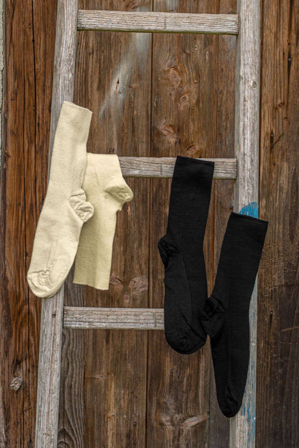 Venensocken Venensocken aus bio Baumwolle (kbA) und bio Wolle (kbT) in naturweiß und schwarz über Holzleiter gehängt