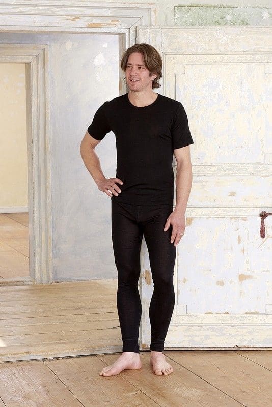 Mann trägt eine schwarze lange Unterhose aus bio Wolle (kbT) und Seide und ein schwarzes Shirt