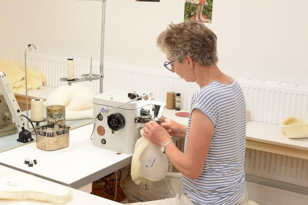 finkhof-manufakturen-fellnaeherei-2 Frau näht in der Finkhof Fellnäherei
