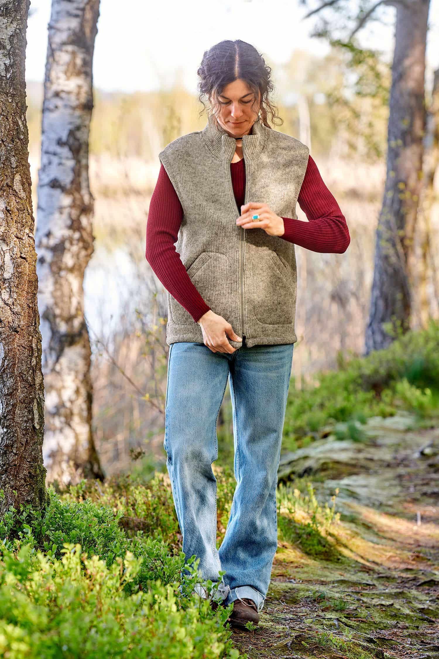 Frau trägt die graue ungefärbte Finkhof Wollwalkweste aus bio Wolle (kbT) ohne Ärmel mit rotem Shirt