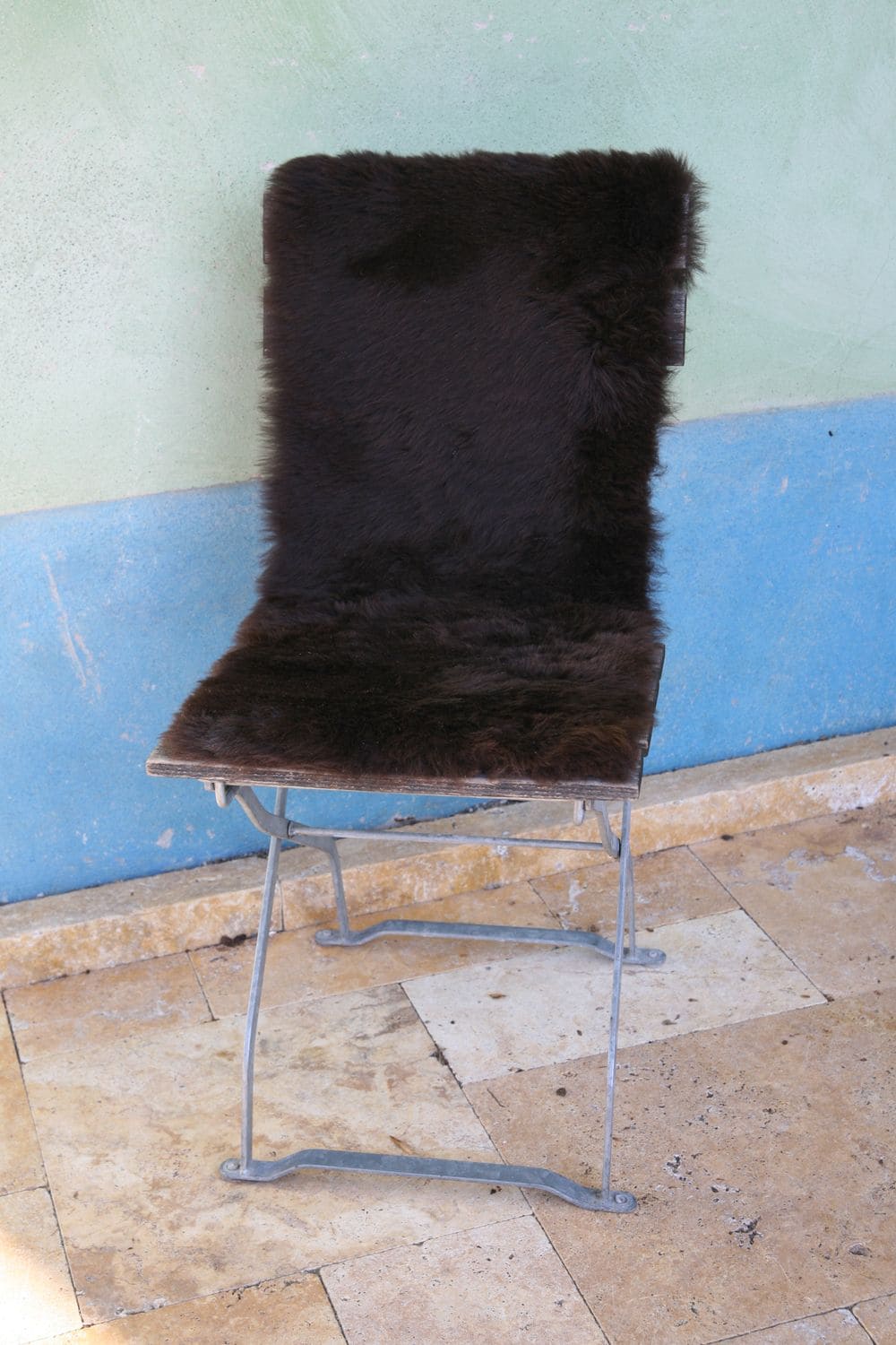 braune Bankfellauflage aus pflanzlich gegerbtem Schaffell vom Finkhof auf einem Stuhl