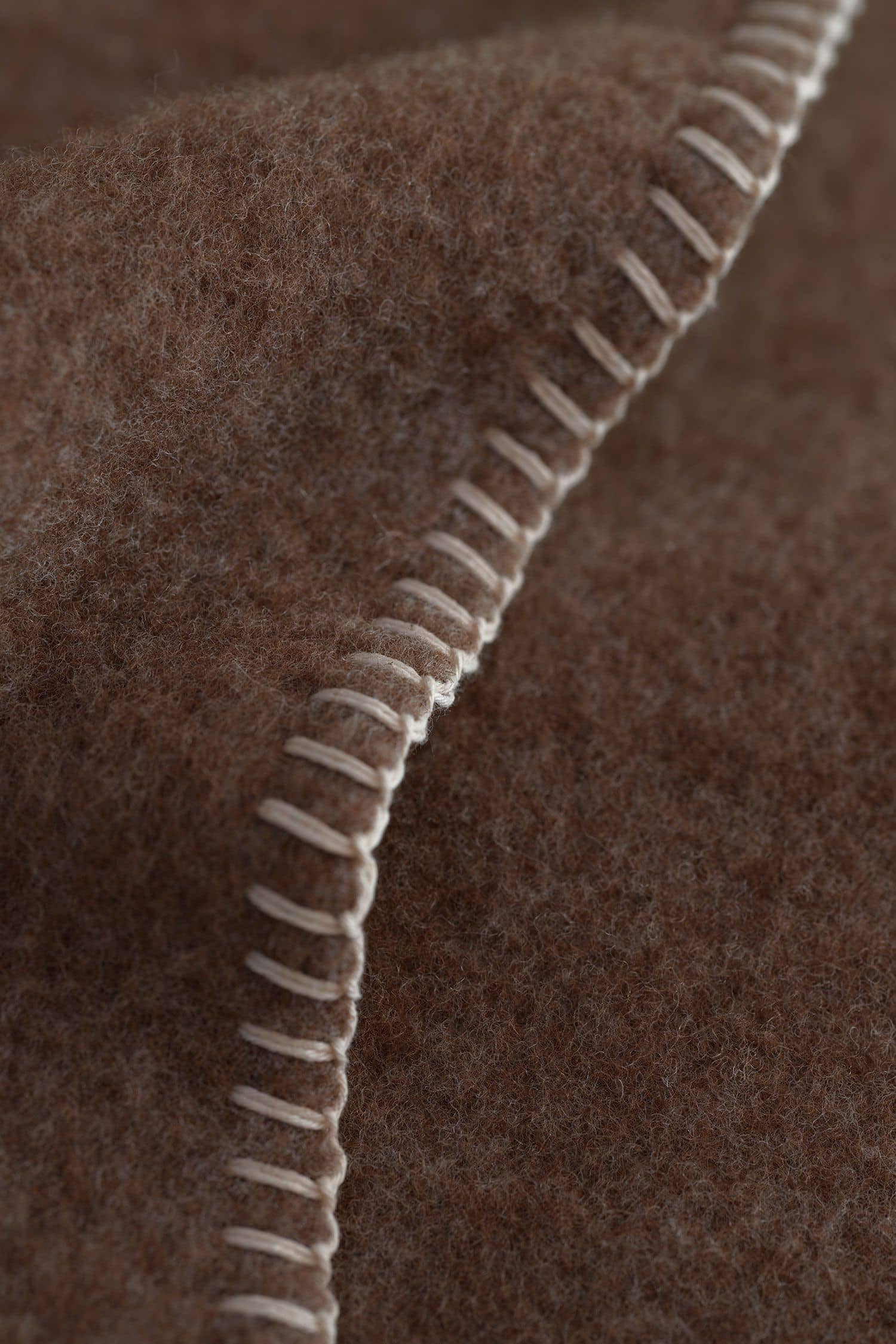 Saum der braune Wolldecke aus bioWolle (kbT) vom Juraschaf