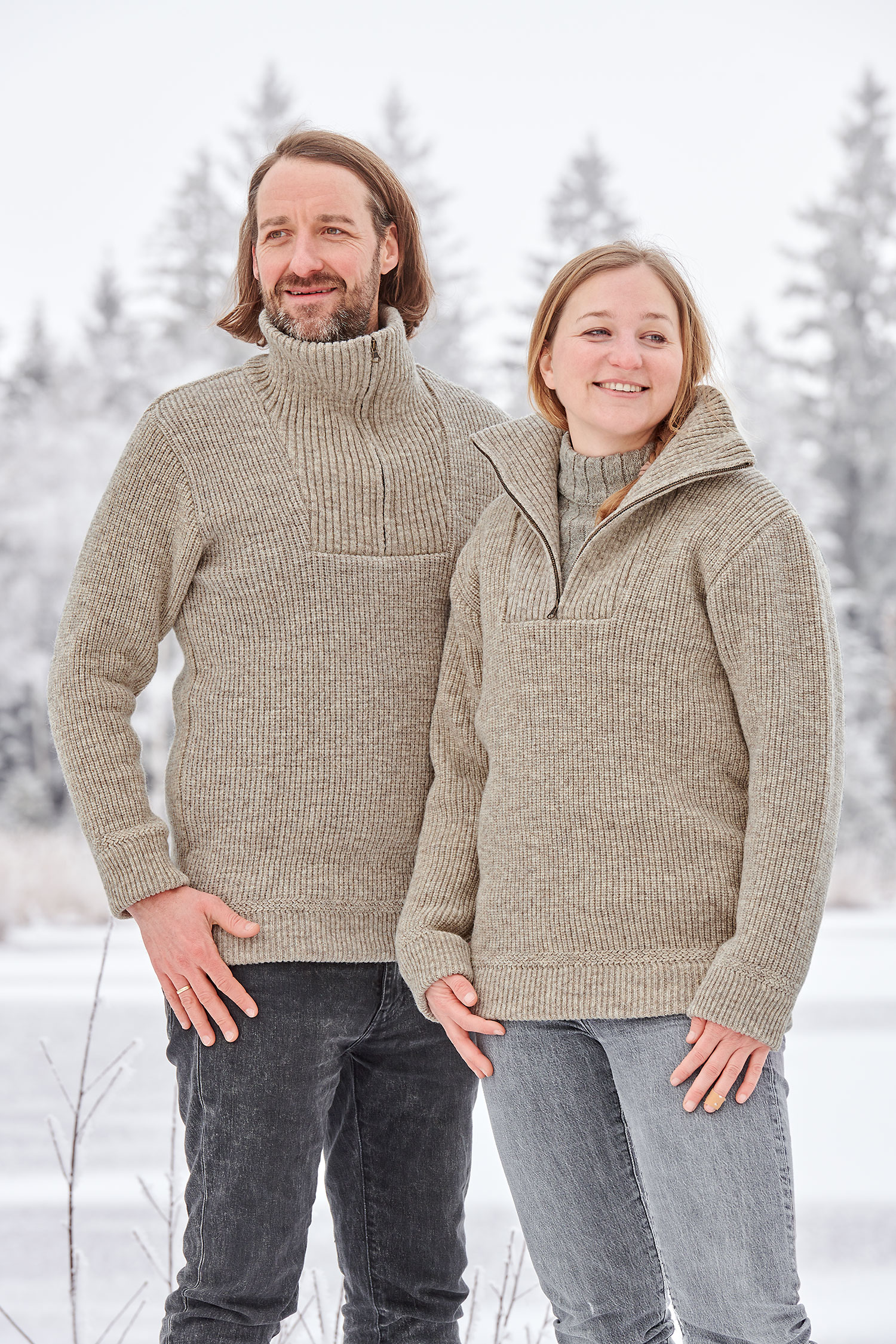 Frau und Mann tragen grauen Finkhof Troyern aus bio Wolle (kbT) in Schneelandschaft