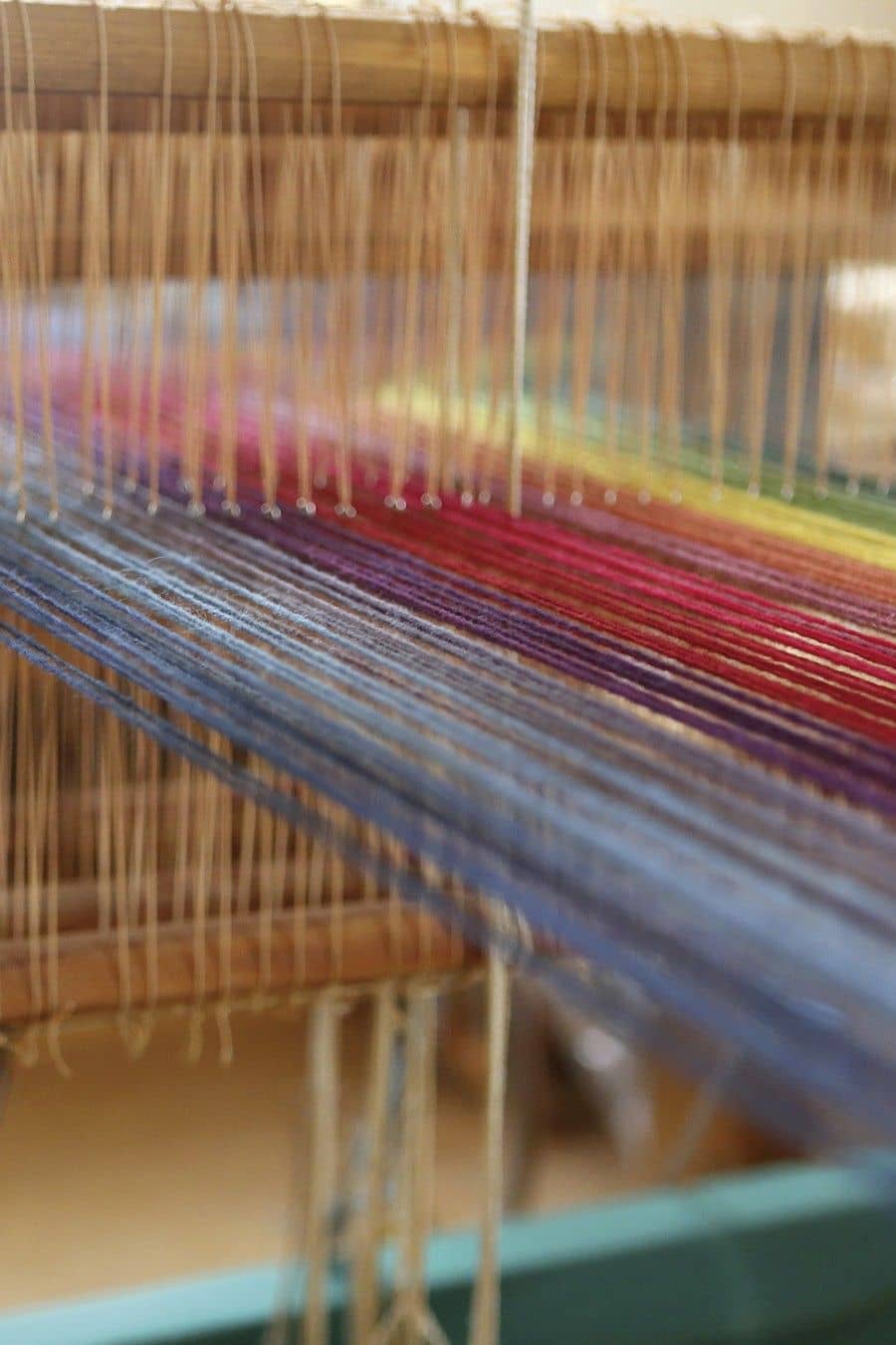 Webstuhl mit regenbogenfarbener Wolle für pflanzengefärbten Wollschal vom Finkhof