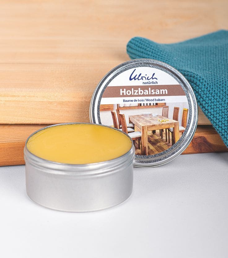 Holzbalsam in geöffnetem 150ml Tiegel mit Holz und türkisem Lappen im Hintergrund