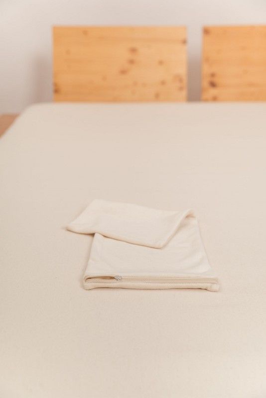 Lendenkissenbezug naturweiß 20 x 50 cm naturweißer Lendenkissenbezug vom Finkhof mit 20x50cm aus bio Baumwolle (kbA) auf Holzbett mit hellem Laken