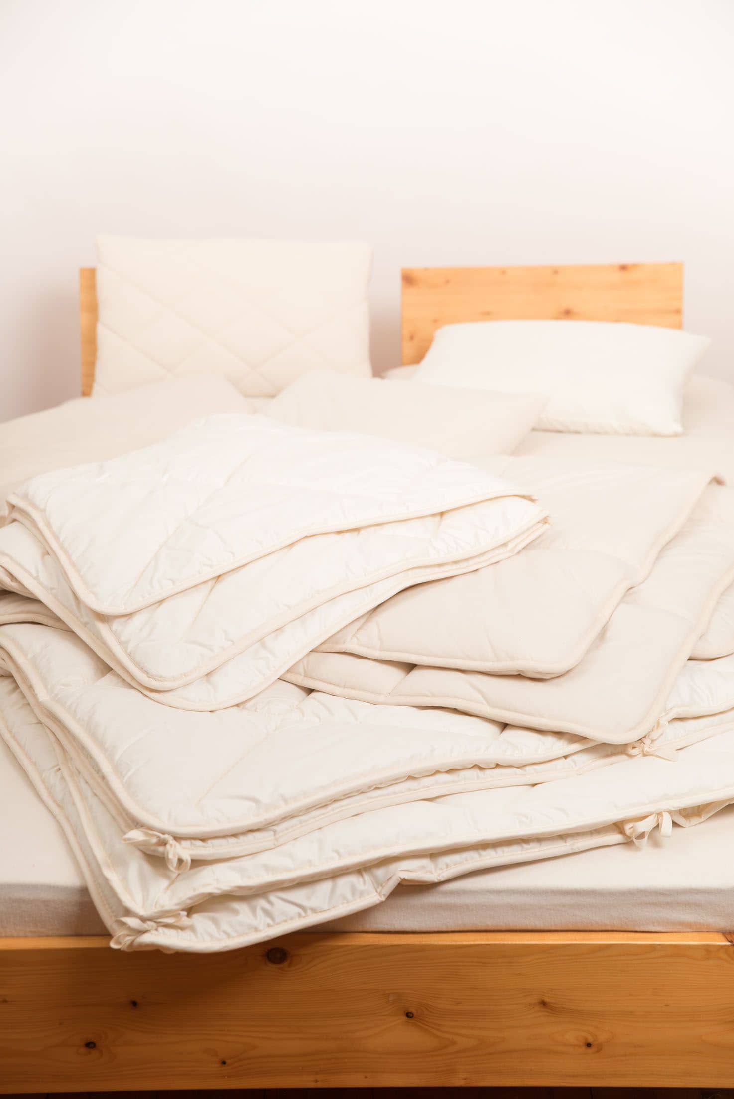 Finkhof Decken und Kissen auf einem Holzbett