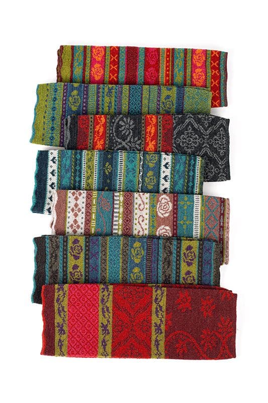 Gemusterte Beinstulpen gemusterte Beinstulpen aus bio Wolle (kbT) in allen sieben Farben leicht versetzt auf weiß gelegt