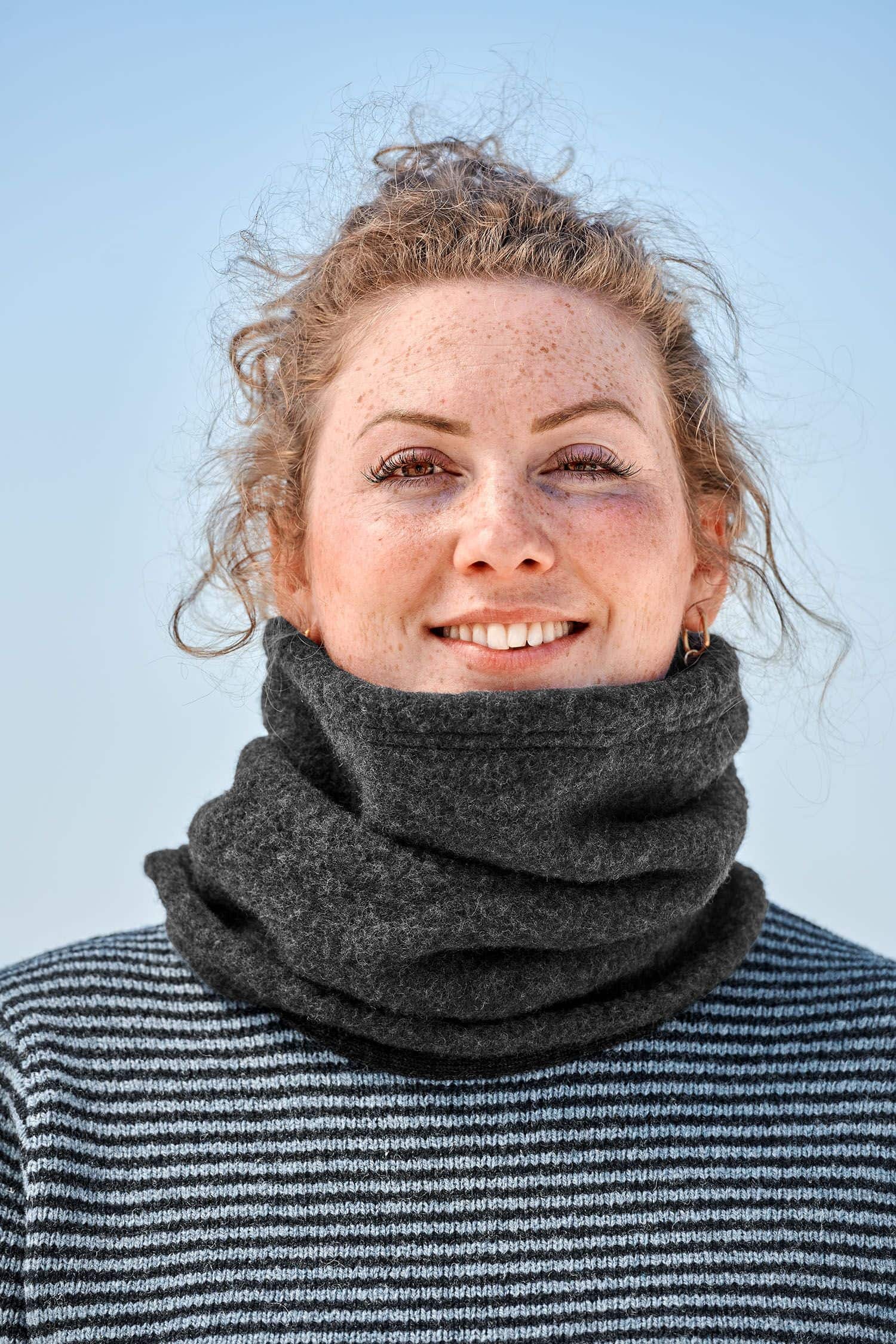 Frau mit Streifenpulli trägt dunkelgrauen Schlupfschal aus bio Merinowolle (kbT) vom Finkhof