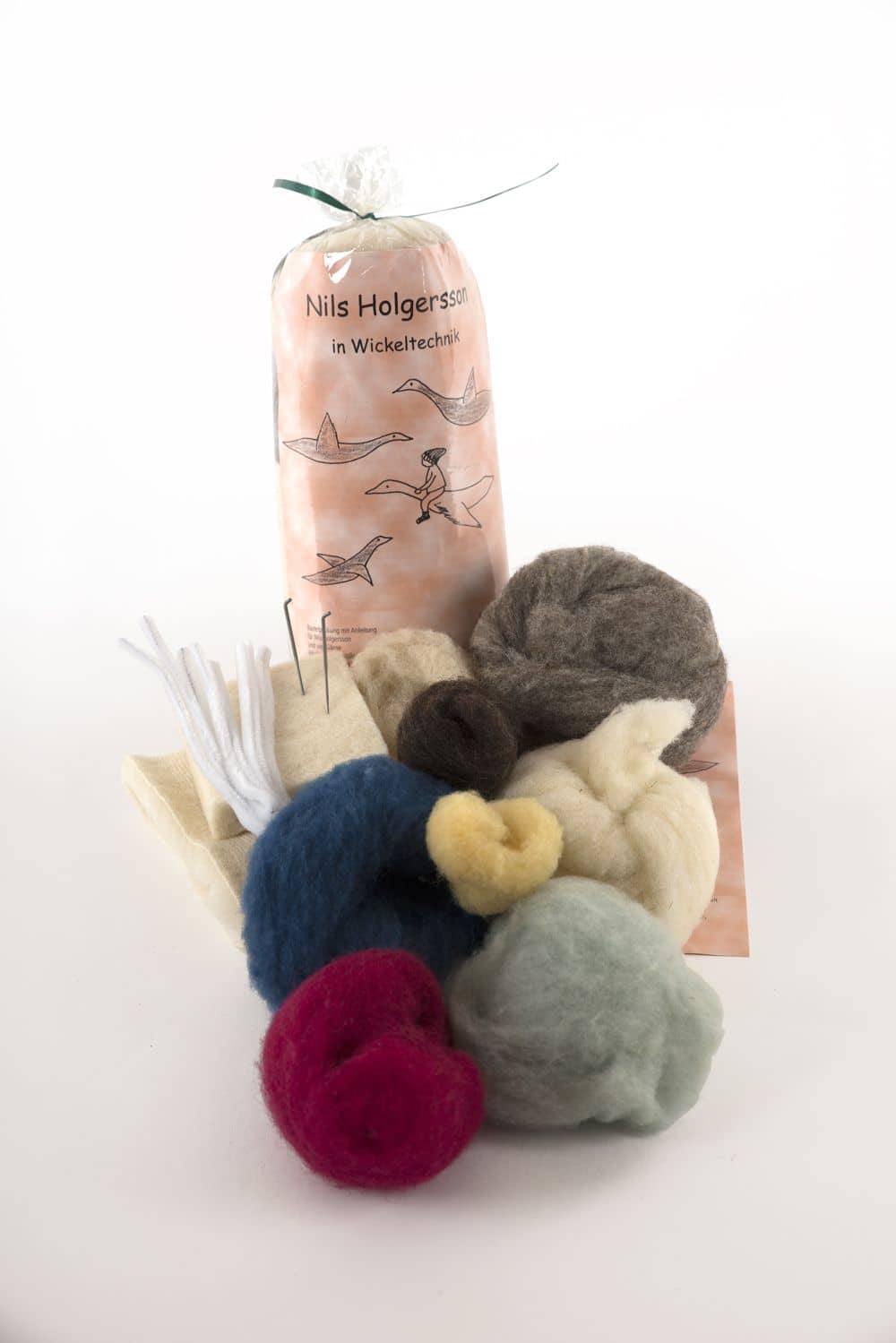 Packungsinhalt der Bastelpackung Nils Holgersson vom Finkhof mit bio Wolle (kbT) und Zubehör auf weißem Untergrund