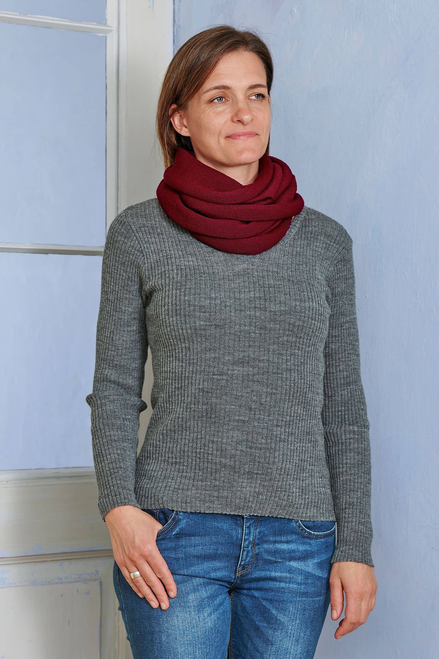 Frau mit grauem Rippshirt trägt bordeauxroten Schlauchschal aus bio Wolle (kbT) vom Finkhof