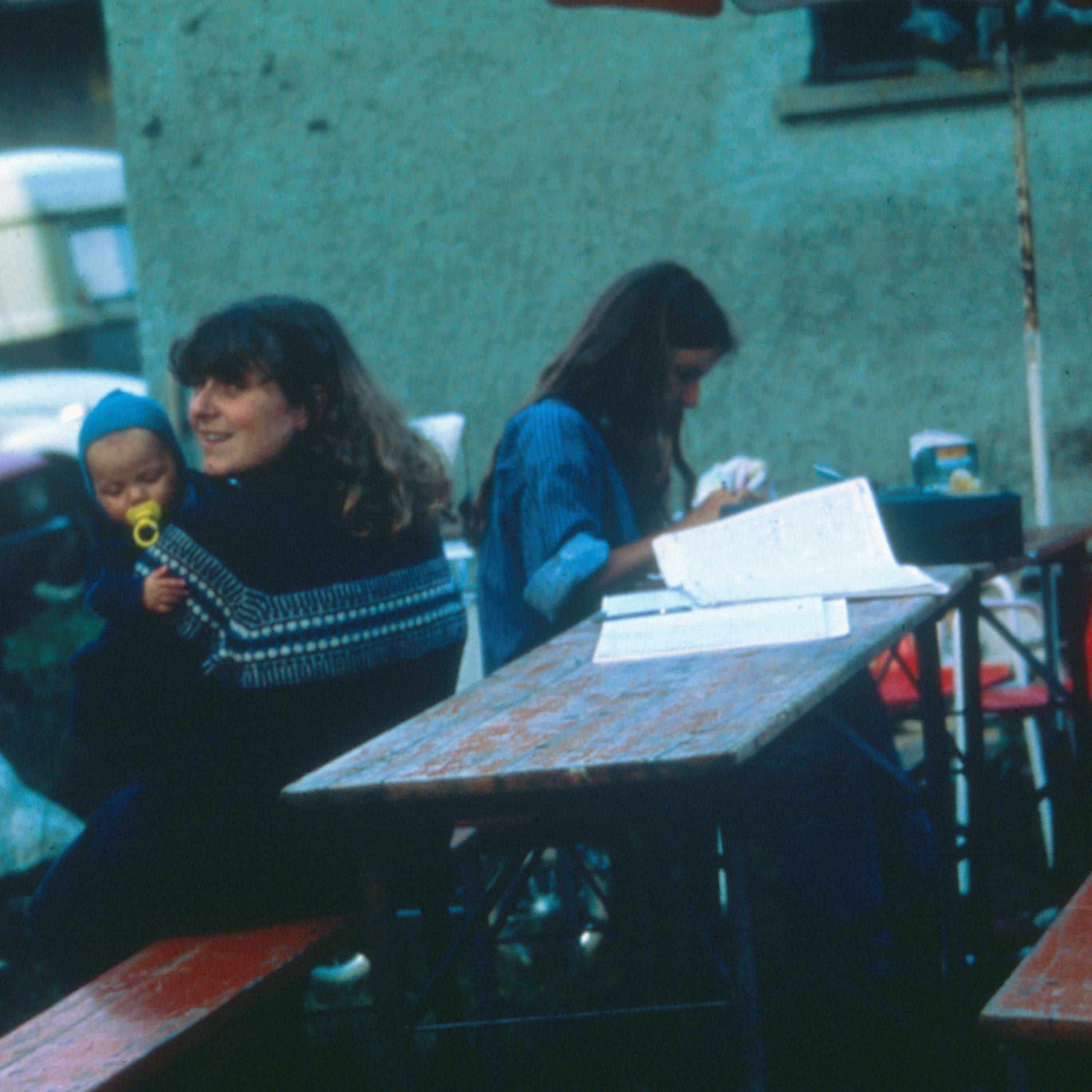 Finkhöflerinnen sitzen mit Kleinkind an einem Tisch