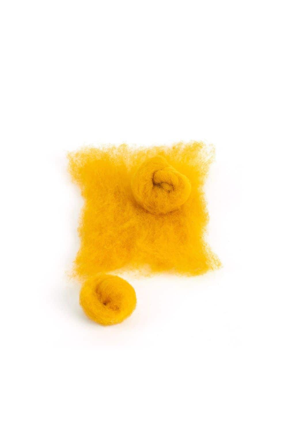 gelbe Finkhof Märchenwolle aus bio Merinowolle (kbT) in 100g Packung mit Wollkugeln davor, weißer Untergrund