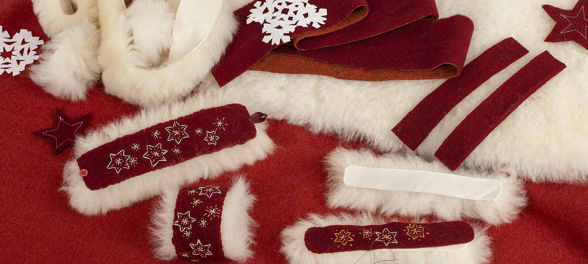 Finkhof Banner für flauschige Armstulpen mit weihnachtlichem rotem Stoff, weißem Fell und aufgestickten Sternen