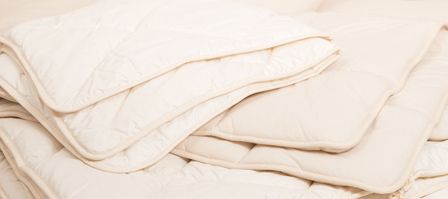 mehrere weiße Bettdecken liegen übereinander