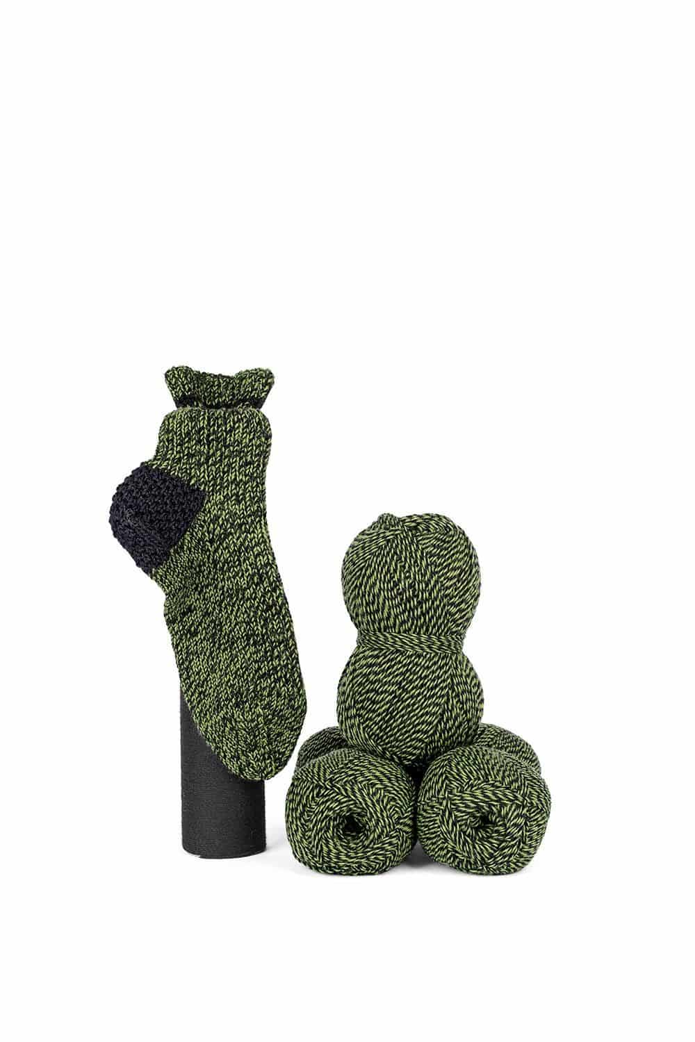 feine Finkhof Sockenwolle mit Melangeeffekt aus bio Wolle (kbT) in grün/ schwarz mit Wollknäulen und Stricksocken