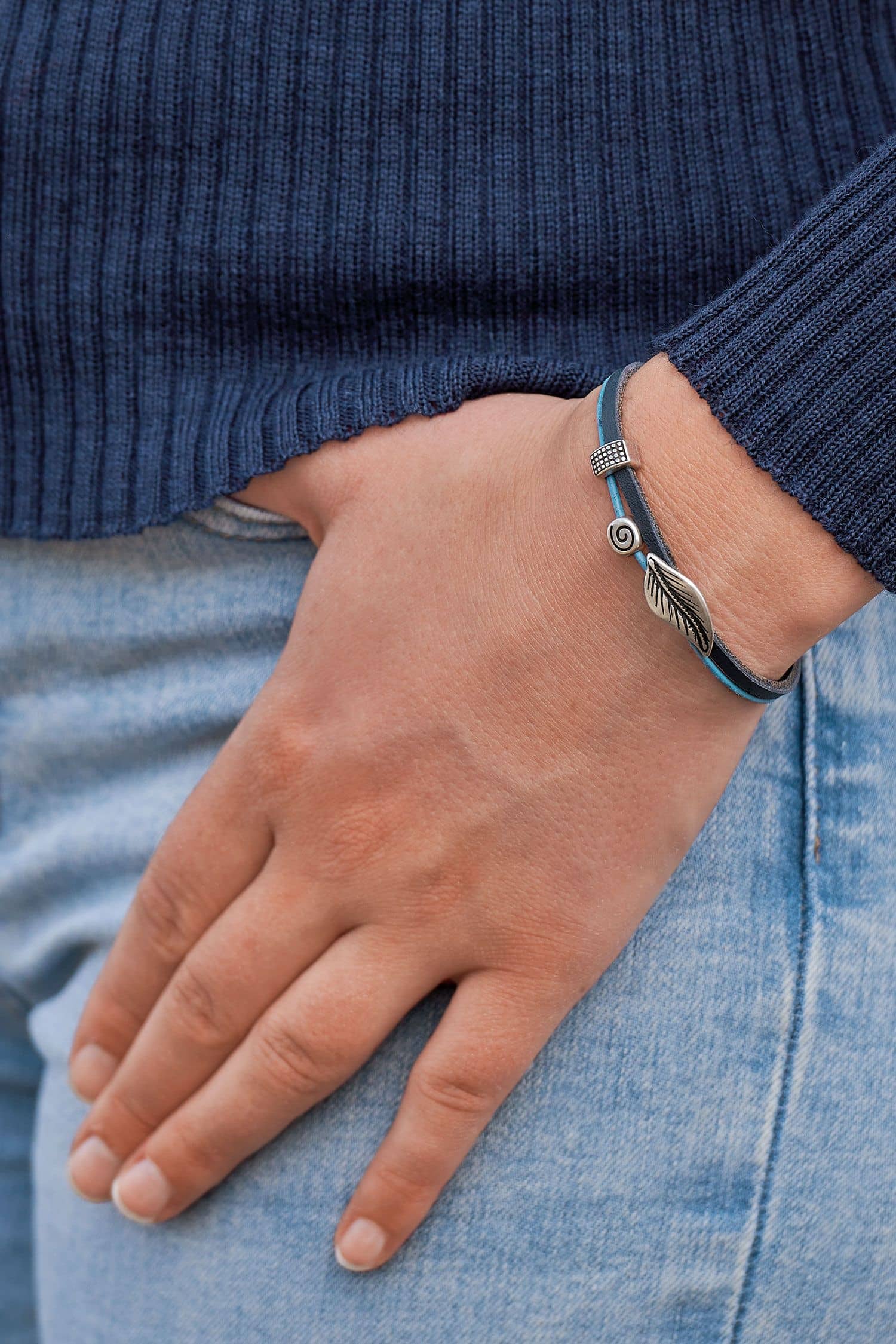 Lederarmband in Blautönen aus pflanzlich gegerbtem Rindsleder mit silbernen Details mit blauem Pulli und Jeans