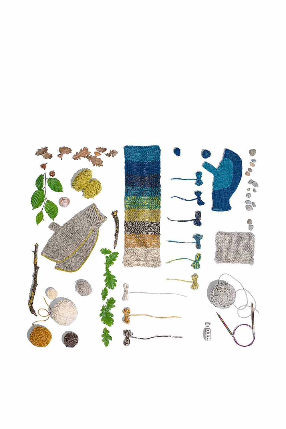 Japanische Handschuhe, verschiedene Wollen, Stricknadeln, Blätter, Kies, Äste