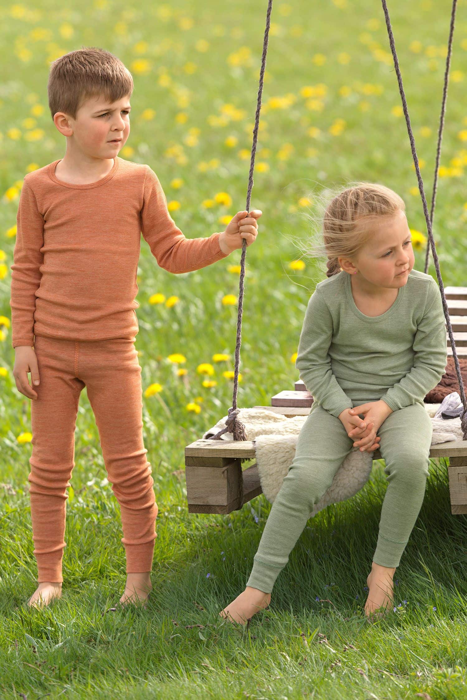 Wollmix lange Kinder-Unterhose - Baumwolle-Wolle-Seide Kinder sitzen auf Schaukel und tragen Lange Unterwäsche aus bio Wolle (kBT), bio Baumwolle (kbA) und Seide
