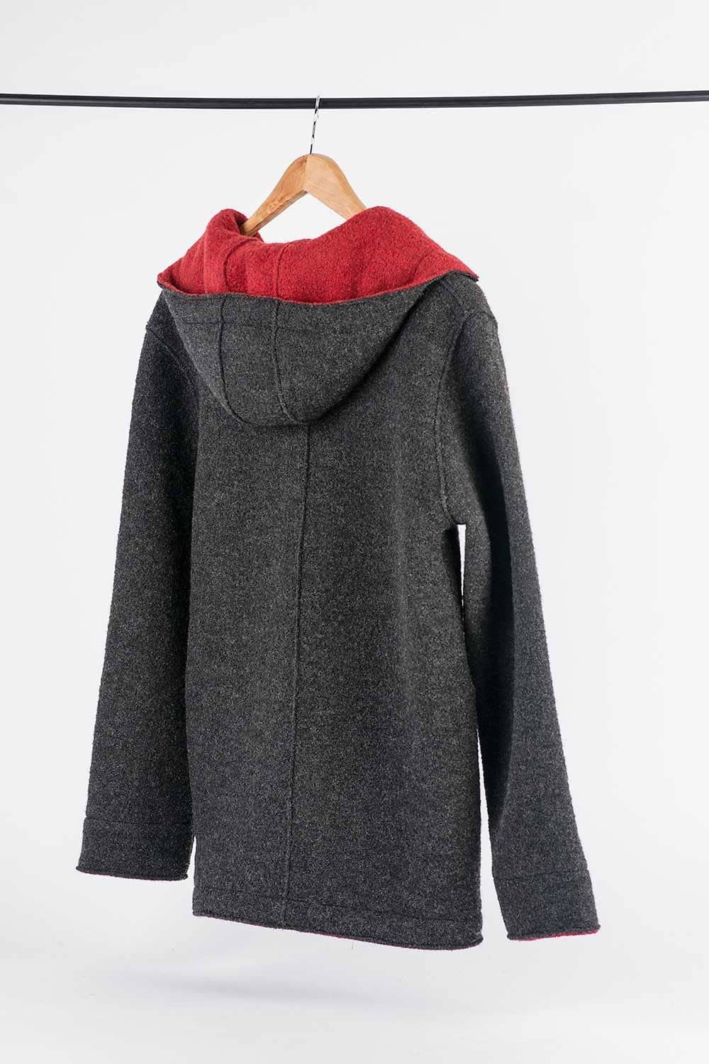 Rückansicht von dunkelgrauer Jacke aus bio Wolle (kbT) vom Finkhof mit Kleiderbügel an Kleiderstange aufgehängt