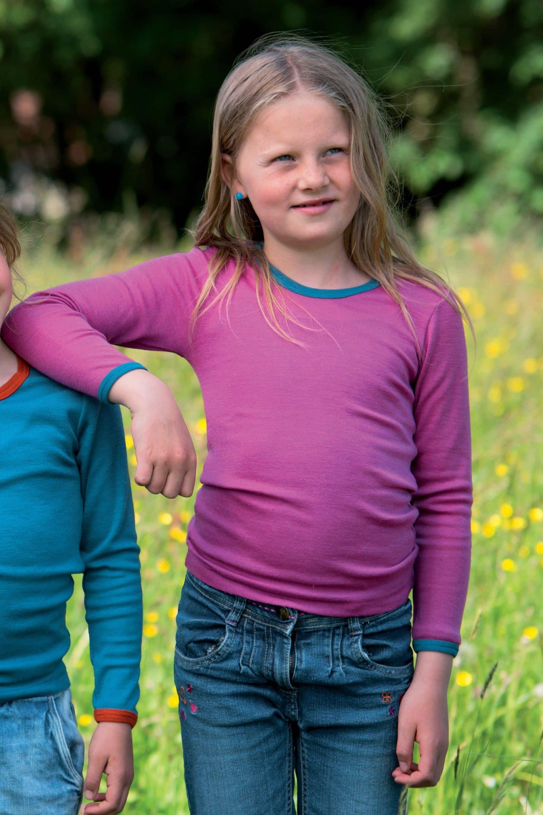 Mädchen trägt pinkes Langarmshirt mit türkisem Kragen aus bio Wolle (kbT) und Seide